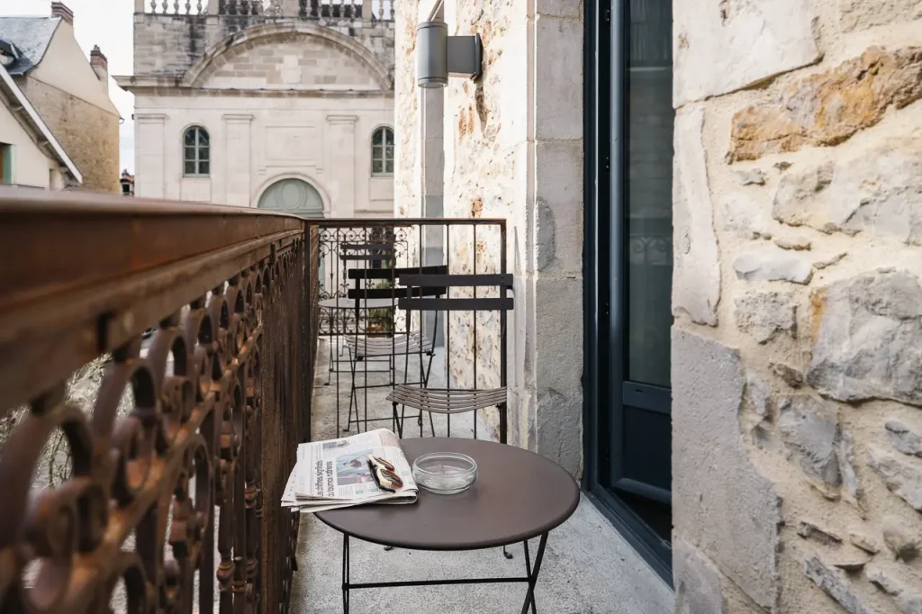Balcon privé avec vue sur la Chapelle des Pénitents Noirs - Hôtel Les Fleurines, hôtel Aveyron à Villefranche-de-Rouergue