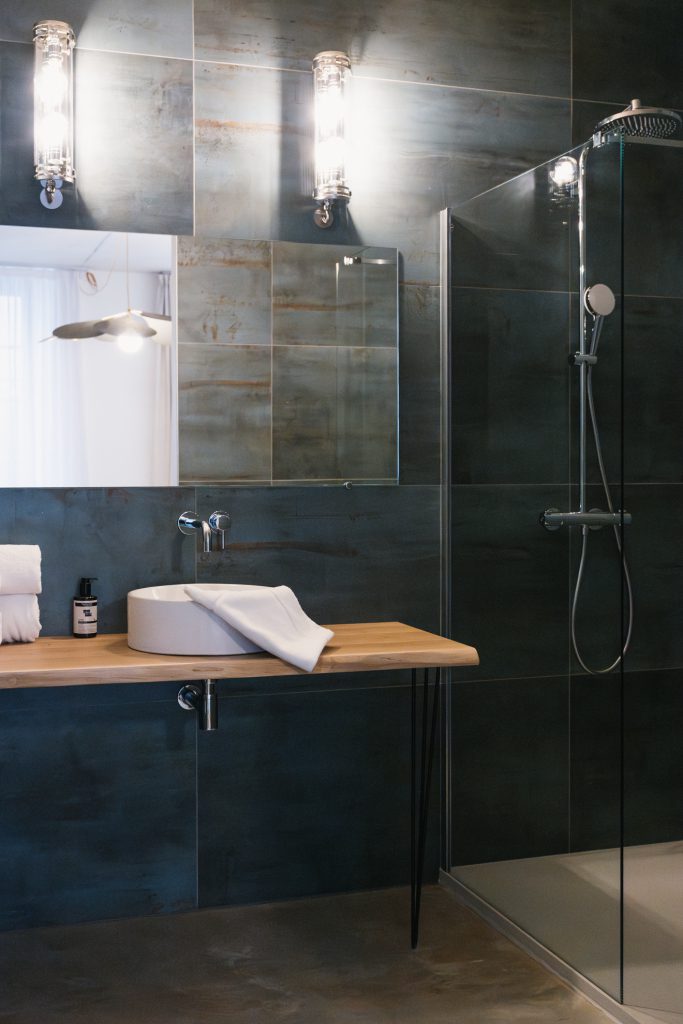 Chambre élégante avec salle de bain moderne, douche spacieuse et équipements haut de gamme, offrant confort et bien-être à la Maison des Cassiers, Hôtel Les Fleurines, Villefranche-de-Rouergue, Aveyron.