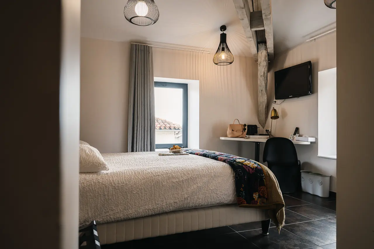 Chambre contemporaine chaleureuse avec poutres apparentes et bureau - Hôtel Les Fleurines, hôtel Aveyron à Villefranche-de-Rouergue