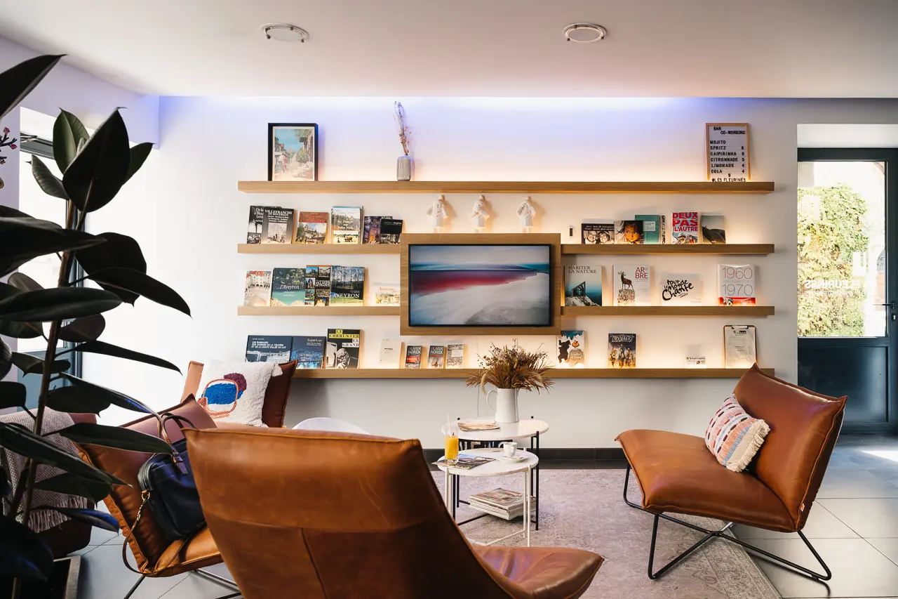 Espace détente et bar avec fauteuils en cuir - Hôtel Les Fleurines, hôtel design en Aveyron à Villefranche-de-Rouergue